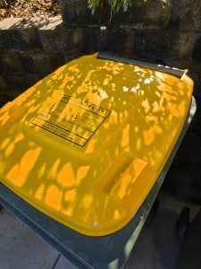 Yellow wheelie bin lid after cleaning