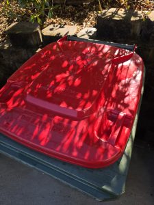Red wheelie bin lid after cleaning