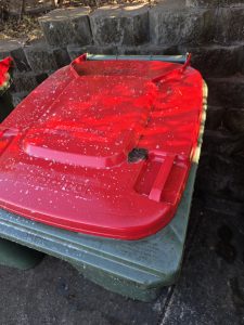 Red wheelie bin lid before cleaning